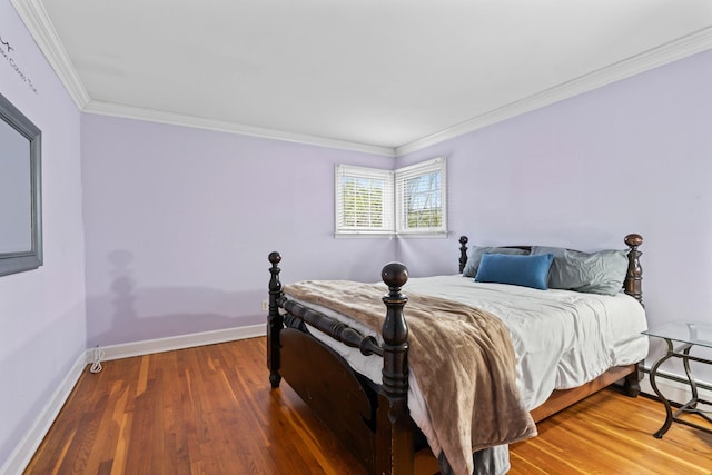 bedroom with baseboards, ornamental molding, and wood finished floors