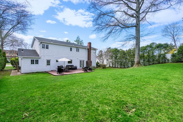 back of house with a lawn, a patio, and a chimney