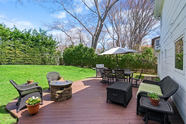wooden deck with a fire pit, grilling area, outdoor dining space, and a lawn