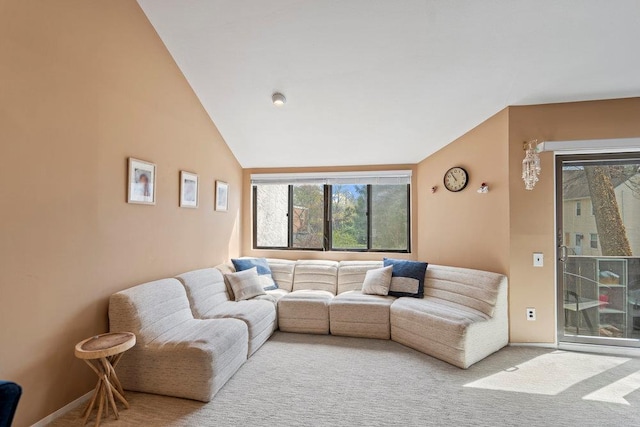 carpeted living area with vaulted ceiling and baseboards