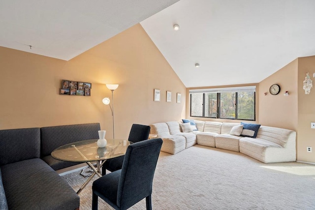 carpeted living area featuring high vaulted ceiling