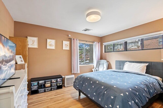 bedroom with light wood-type flooring and visible vents