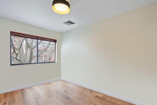 empty room featuring baseboards, visible vents, and light wood-style flooring