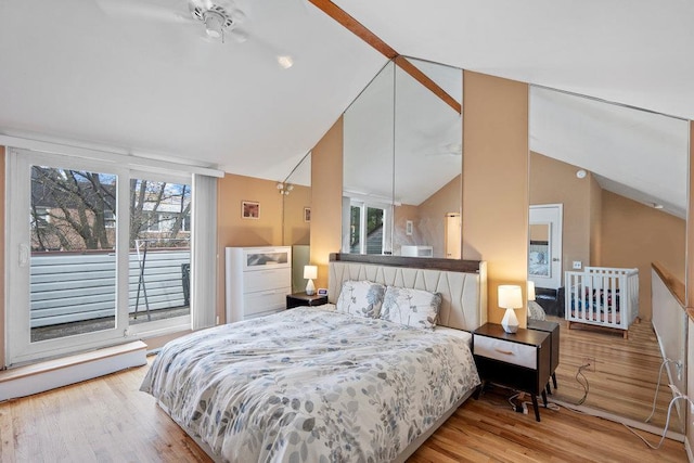 bedroom featuring lofted ceiling, wood finished floors, and multiple windows