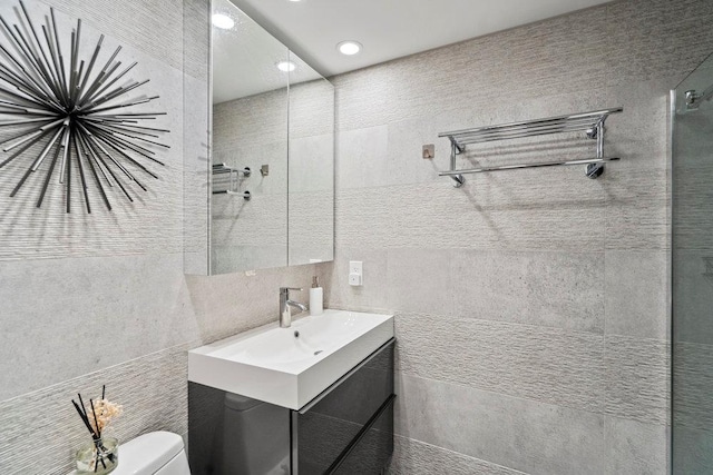 full bath featuring recessed lighting, toilet, vanity, tile walls, and tiled shower