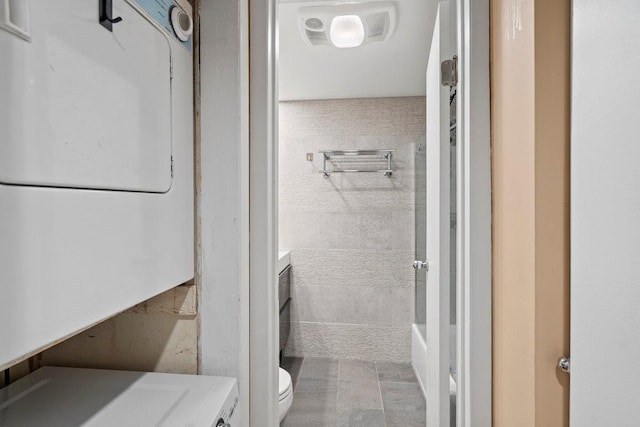 full bathroom with washer / dryer, toilet, and vanity