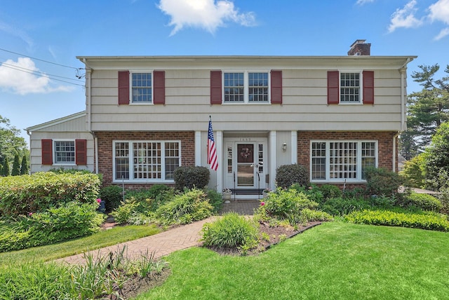 1449 Riverview Ave, Peekskill, NY 10566 - colonial house featuring brick siding, a chimney, and a front lawn