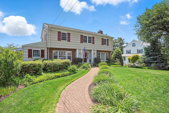 1449 Riverview Ave, Peekskill, NY 10566 - colonial-style house with brick siding, a chimney, and a front yard