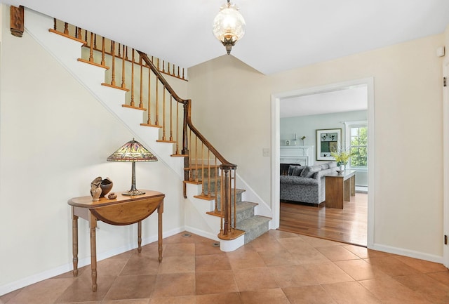 1449 Riverview Ave, Peekskill, NY 10566 - staircase featuring baseboards, tile patterned floors, and a fireplace