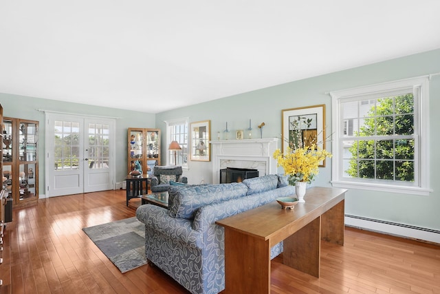 1449 Riverview Ave, Peekskill, NY 10566 - living room with wood-type flooring, a high end fireplace, a baseboard radiator, and french doors