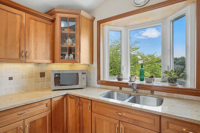 1449 Riverview Ave, Peekskill, NY 10566 - kitchen featuring a sink, plenty of natural light, glass insert cabinets, and brown cabinets