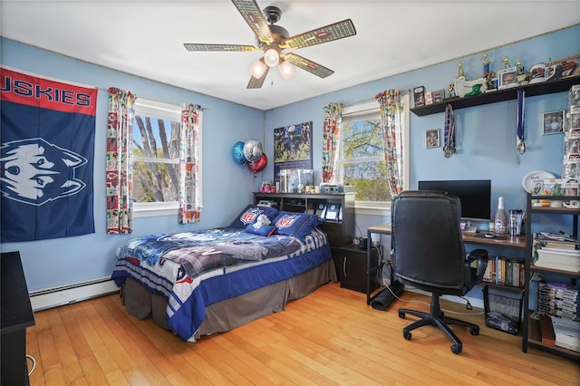 bedroom with baseboard heating, ceiling fan, and wood-type flooring