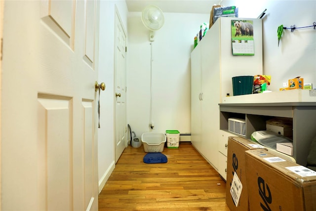 interior space featuring baseboard heating and wood finished floors