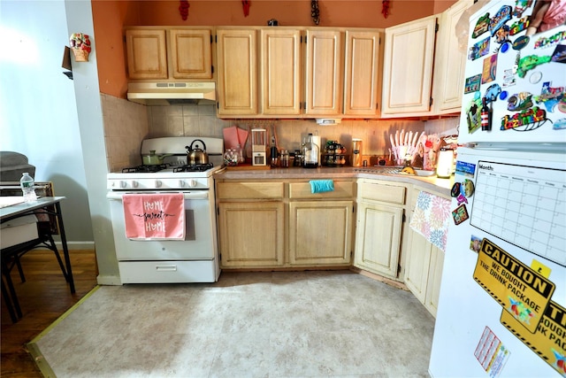 kitchen featuring light brown cabinetry, backsplash, under cabinet range hood, and white appliances