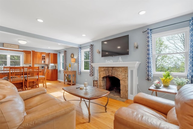 living room with light wood-type flooring, recessed lighting, and a healthy amount of sunlight