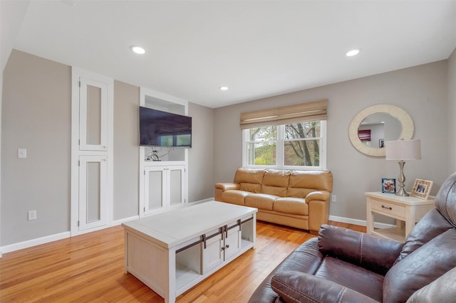 living area featuring recessed lighting, baseboards, and light wood finished floors