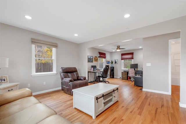 living room featuring a ceiling fan, baseboards, recessed lighting, and light wood finished floors