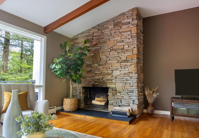 living area with wood finished floors, baseboards, a fireplace, and a baseboard heating unit
