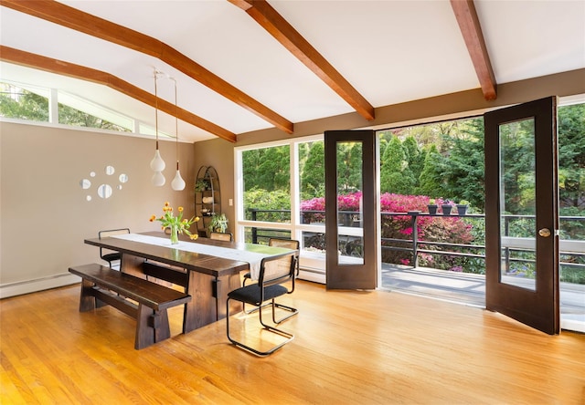 dining area featuring light wood-type flooring, a baseboard radiator, and plenty of natural light