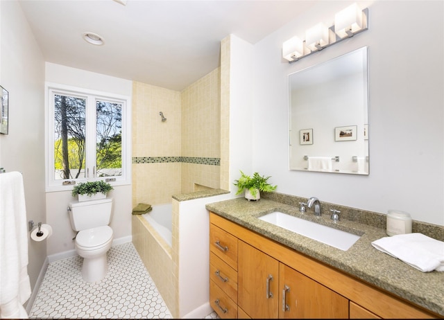 bathroom featuring toilet, vanity, and tiled shower / bath combo