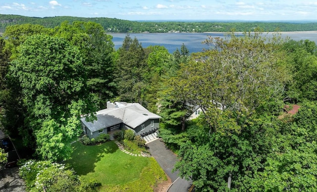 drone / aerial view of a large body of water and a heavily wooded area