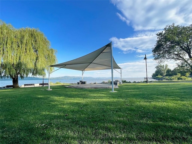 view of property's community with a lawn and a water view