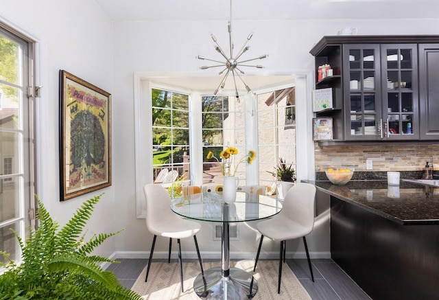 dining space featuring a chandelier, baseboards, and wood finished floors