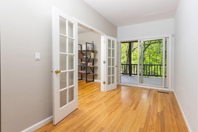 doorway to outside featuring french doors, light wood-type flooring, and baseboards