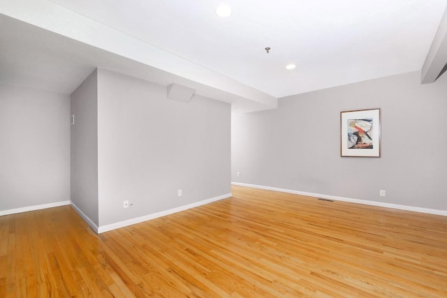 unfurnished room with baseboards, light wood finished floors, recessed lighting, and fire sprinkler in ceiling