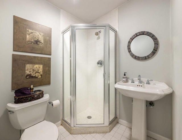 bathroom featuring a stall shower, toilet, baseboards, and tile patterned floors