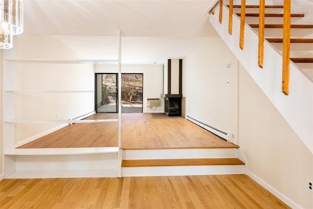 52 Round Hill Rd, Dobbs Ferry, NY 10522 - interior space featuring baseboard heating, wood finished floors, stairway, baseboards, and an AC wall unit