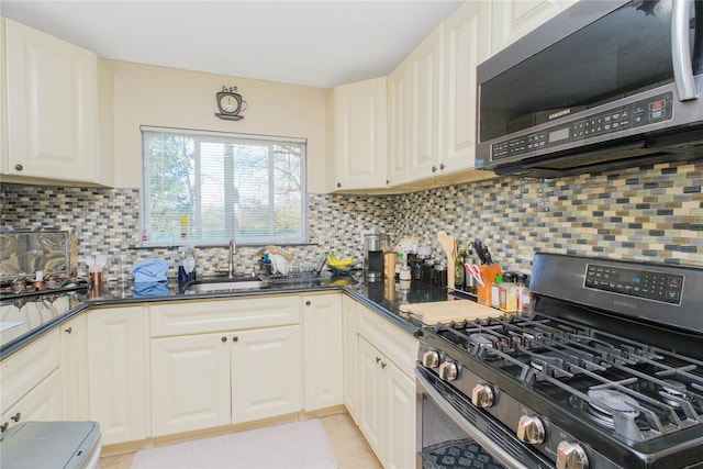 16 Alberta Ave, Staten Island, NY 10314 - kitchen featuring backsplash, a sink, light tile patterned flooring, appliances with stainless steel finishes, and white cabinetry