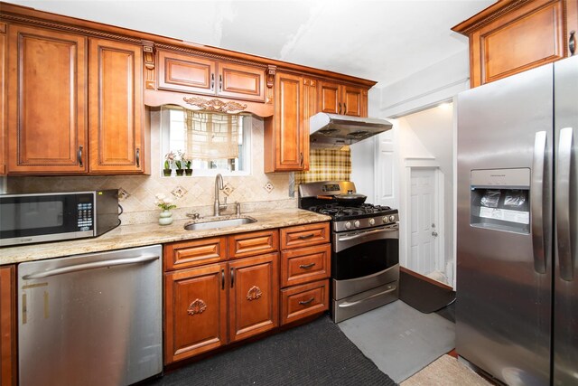 6 Walnut Pl, Great Neck, NY 11021 - kitchen with tasteful backsplash, a sink, brown cabinetry, appliances with stainless steel finishes, and under cabinet range hood
