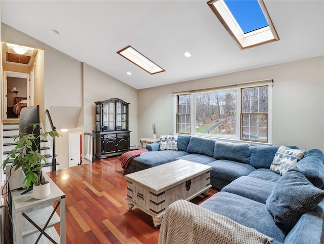 living area featuring a baseboard radiator, vaulted ceiling with skylight, wood finished floors, and recessed lighting