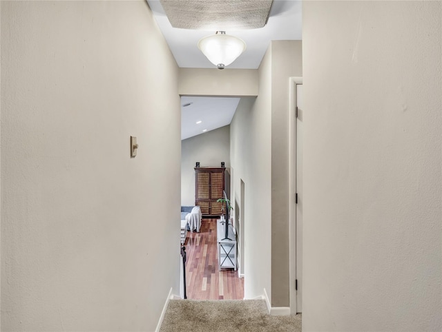 hallway featuring carpet floors and baseboards