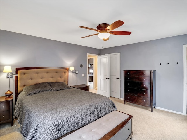 bedroom with a closet, light carpet, a ceiling fan, and baseboards