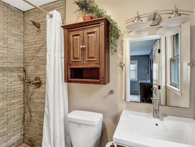 bathroom featuring vanity, toilet, tiled shower, and baseboard heating