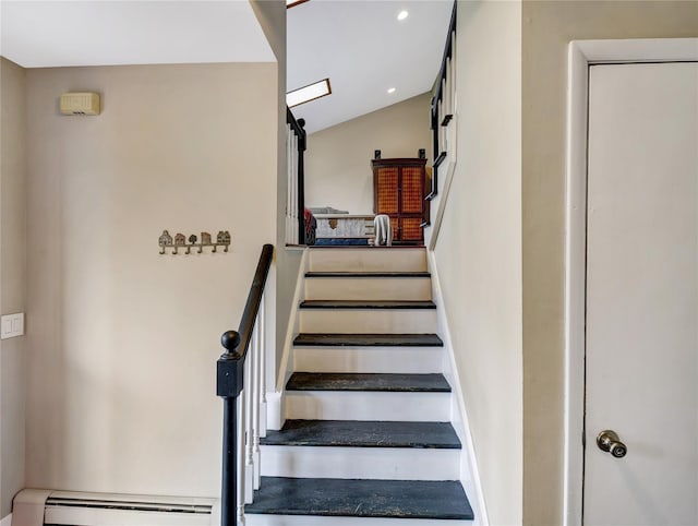 stairs with a baseboard heating unit and recessed lighting