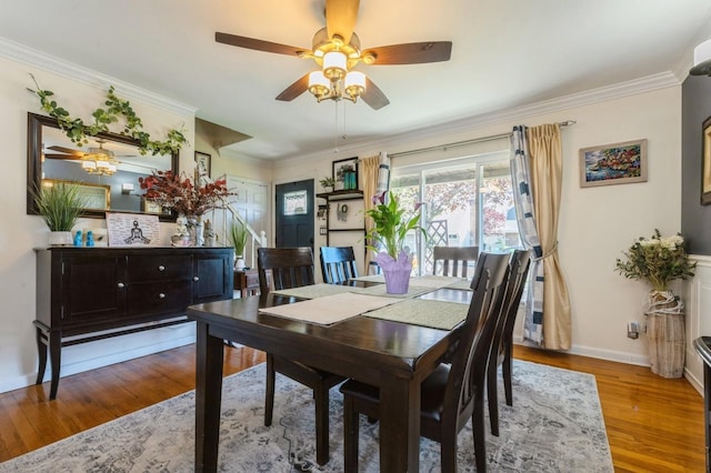 dining room with baseboards, a ceiling fan, wood finished floors, and ornamental molding