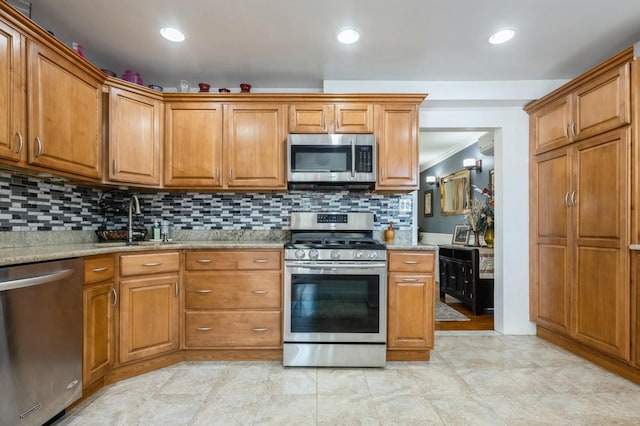 kitchen with brown cabinets, appliances with stainless steel finishes, and a sink