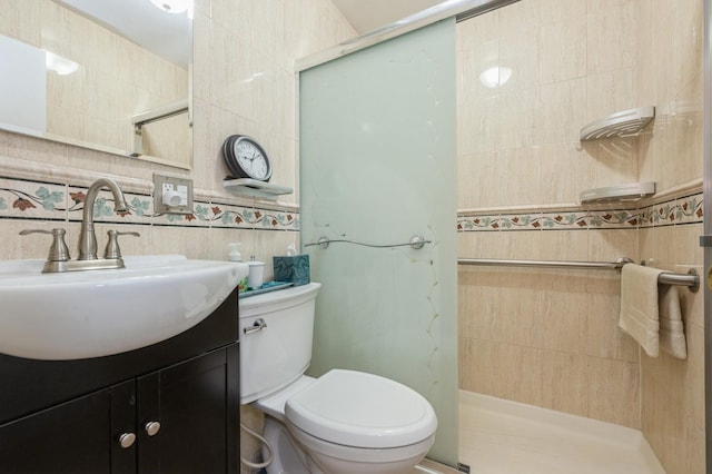 bathroom featuring vanity, a stall shower, toilet, and tile walls