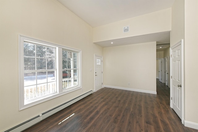 unfurnished room featuring a baseboard radiator, visible vents, baseboards, and dark wood-style flooring