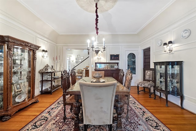 1271 Beverly Rd, Douglaston, NY 11363 - dining area featuring light wood-type flooring, a notable chandelier, stairway, and a decorative wall