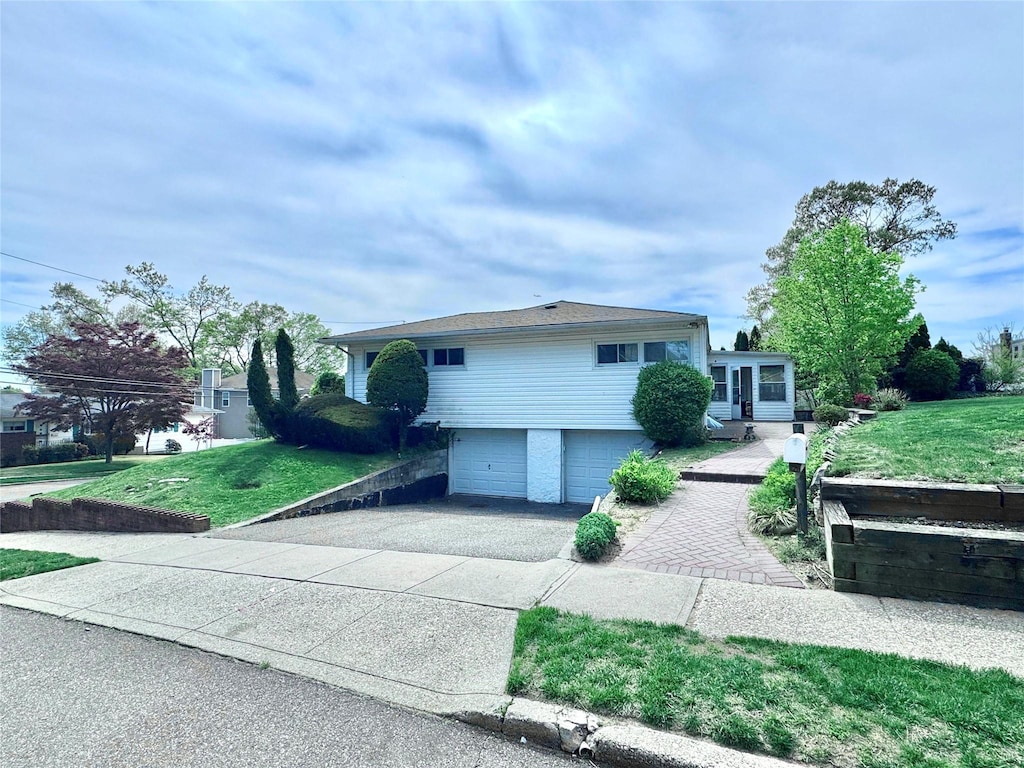 tri-level home featuring driveway, a front yard, and a garage