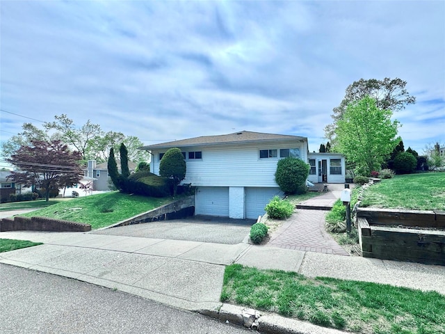 tri-level home featuring driveway, a front yard, and a garage