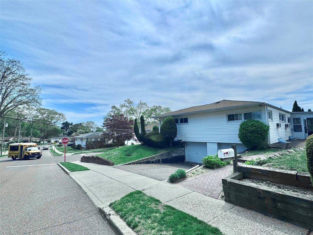 view of property exterior with an attached garage and driveway
