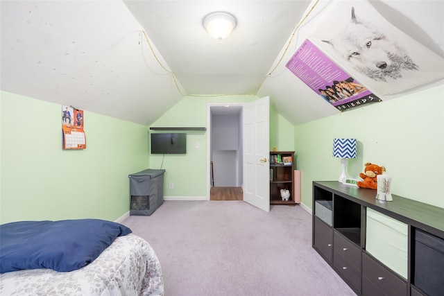 bedroom with lofted ceiling, baseboards, and light colored carpet