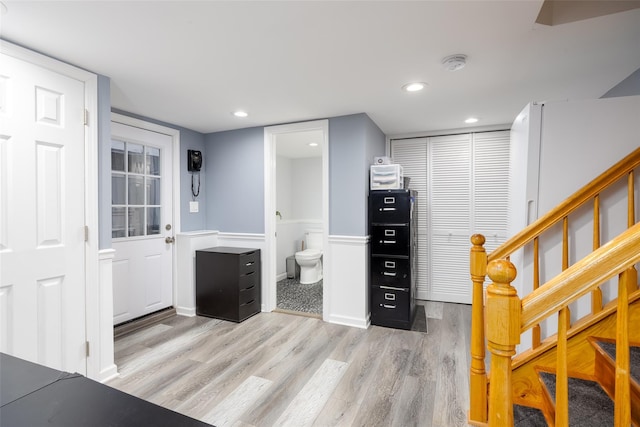 foyer entrance featuring wainscoting, recessed lighting, stairs, and light wood-style flooring