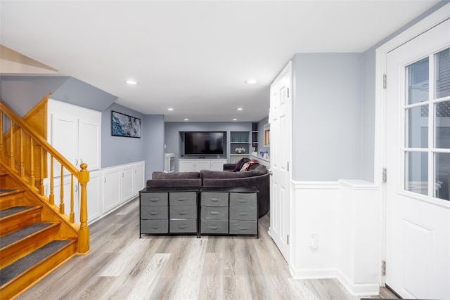 bar featuring recessed lighting, a wainscoted wall, stairs, and light wood-type flooring