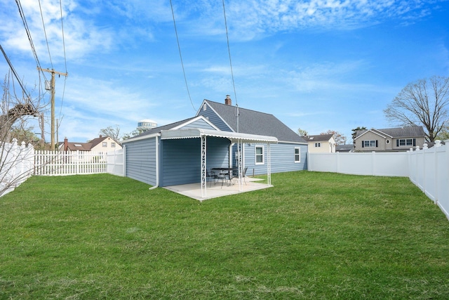 back of property featuring a lawn, a fenced backyard, a patio area, and a chimney